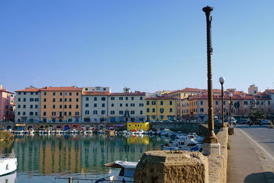 Buildings in city against clear blue sky