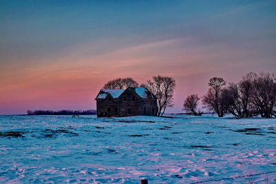House by sea against sky during sunset