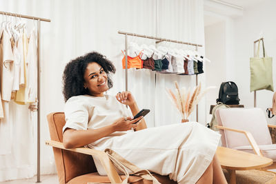 Young woman using mobile phone while sitting at home