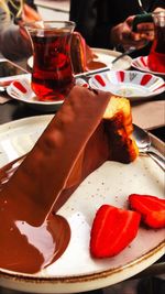 Close-up of hand holding ice cream on table in restaurant