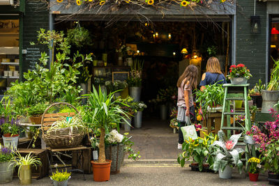 Rear view of women standing at flower shop
