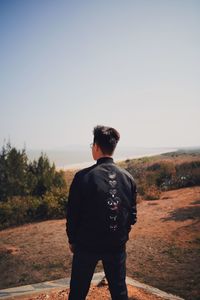 Rear view of man looking at camera