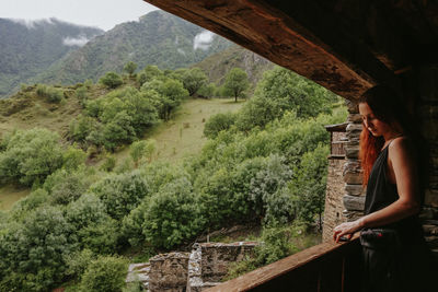 Woman looking at view of mountain in forest