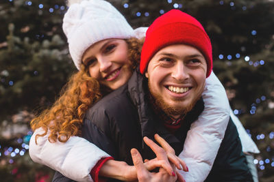 Portrait of smiling couple against tree