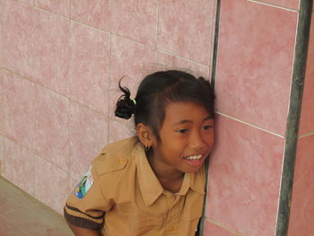 Portrait of smiling girl standing on tiled floor