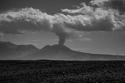 Smoke emitting from volcanic mountain against sky