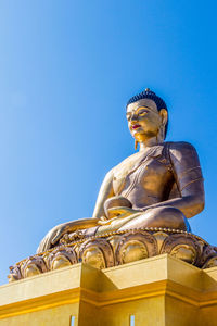 Low angle view of statue against blue sky