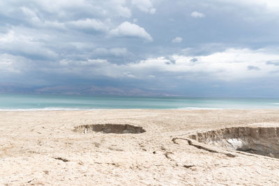 Sinkhole filled with turquoise water, near dead sea coastline. hole formed when underground salt is