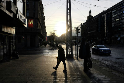 Silhouette of man walking on city street