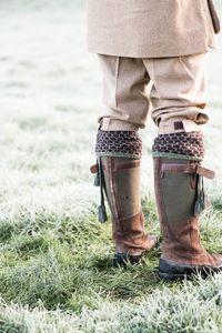 Low section of person wearing traditional clothing while standing on grass