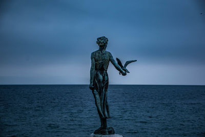 Statue against sea against sky