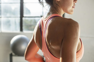 Midsection of female athlete standing in gym