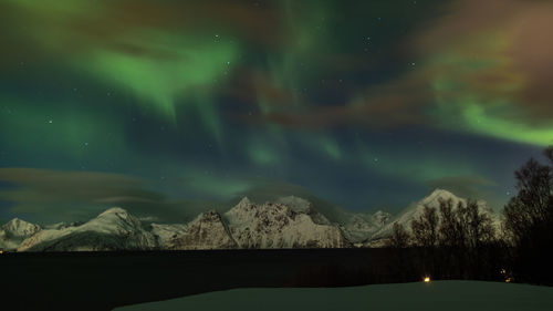 Scenic view of snowcapped mountains against sky at night