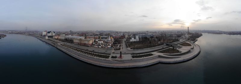 High angle view of buildings by river against sky