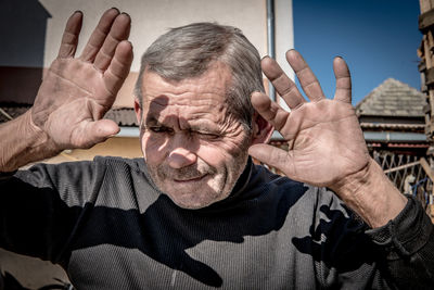 Portrait of man with arms raised