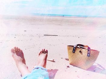Low section of man relaxing on sand