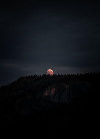 Silhouette landscape against sky at night