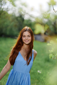 Portrait of young woman standing on field