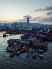 High angle view of cityscape by sea against sky during sunset