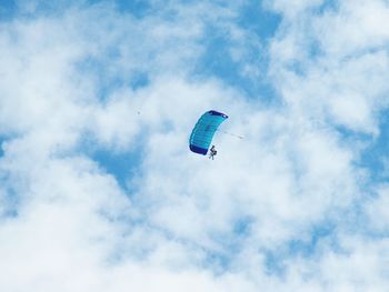 Low angle view of person paragliding against sky