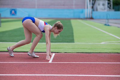 Full length of woman exercising on soccer field