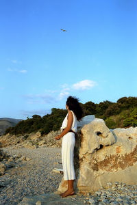 Rear view of woman standing on rock