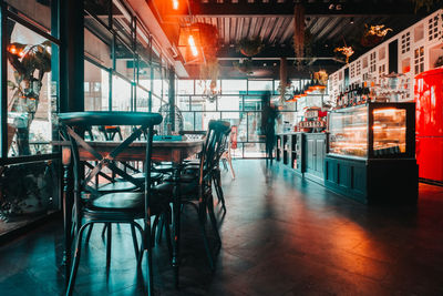 Empty chairs and tables in restaurant at night