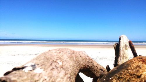 Scenic view of beach against clear blue sky