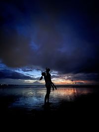 Mother plays with her son with sunset as a background