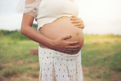 Midsection of woman standing on field