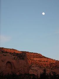 Low angle view of moon against clear blue sky