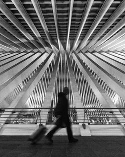 Low angle view of person walking on bridge