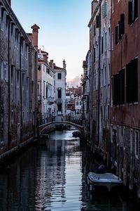 Canal amidst buildings against sky in city