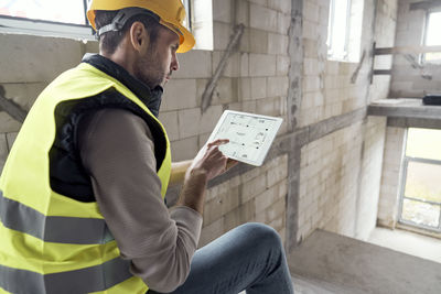 Side view of man using digital tablet at site