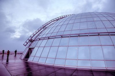 Low angle view of modern building against cloudy sky