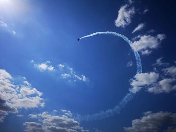 Low angle view of airplane flying against blue sky