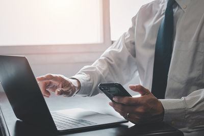 Midsection of man using mobile phone