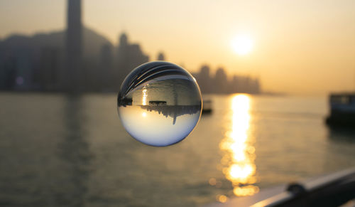 Close-up of crystal ball against sky during sunset