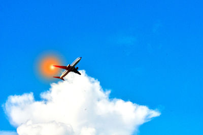 Low angle view of airplane against blue sky