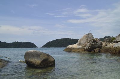 Rocks on sea shore against sky