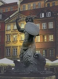 Statue against building in city