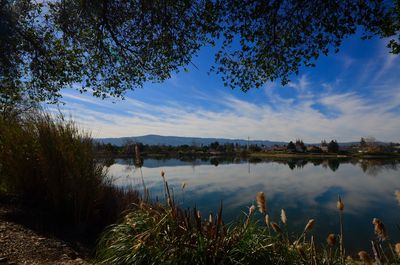 Scenic view of lake against cloudy sky