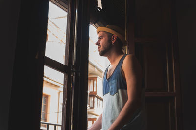 Young man looking towards window at home