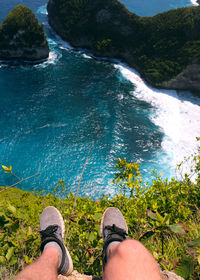 Low section of man standing in sea