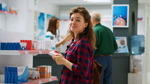 Portrait of young woman standing in store