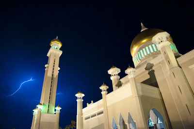 Low angle view of illuminated building against sky at night