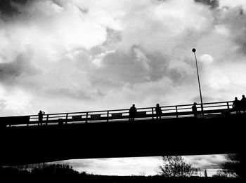 Low angle view of bridge against cloudy sky