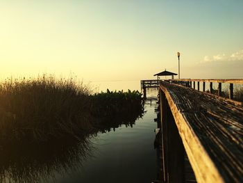 Pier on beach during sunset