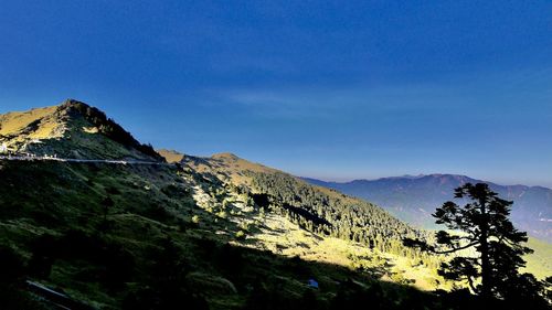Scenic view of mountains against blue sky
