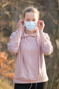 Portrait of mid adult woman wearing mask standing outdoors